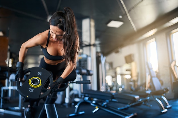 Foto gratuita donna che fa esercizio di iperestensione in palestra