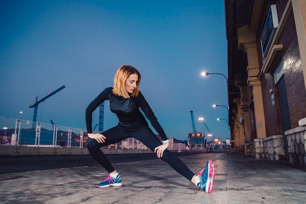 Free photo woman doing legs exercises on street