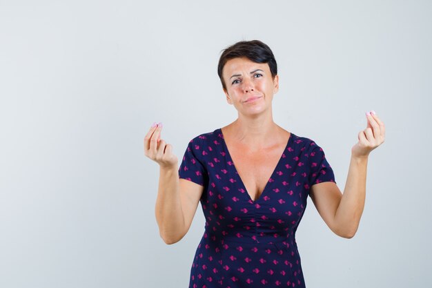 Woman doing money gesture in dress and looking indigent.