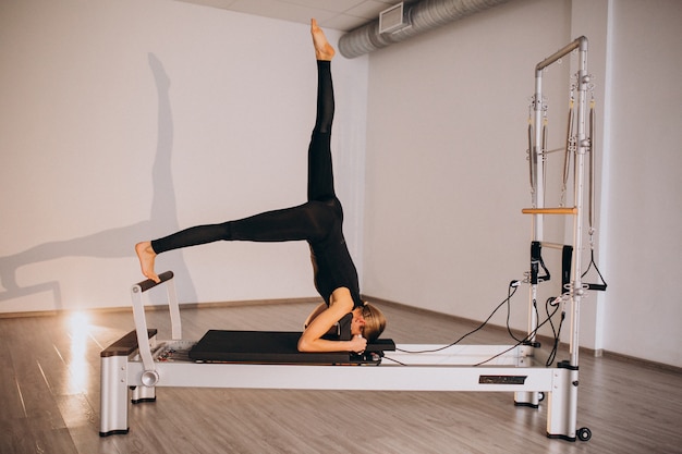 Foto gratuita donna che fa pilates su un riformatore