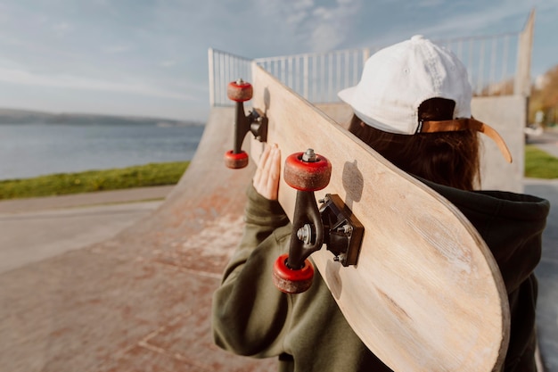 Woman doing skateboard tricks next to a lake