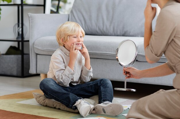 Woman doing speech therapy with a little blonde boy