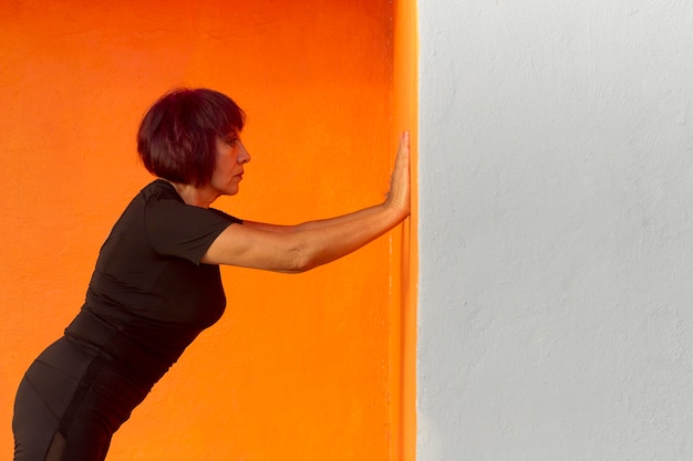 Woman doing sport on an orange wall