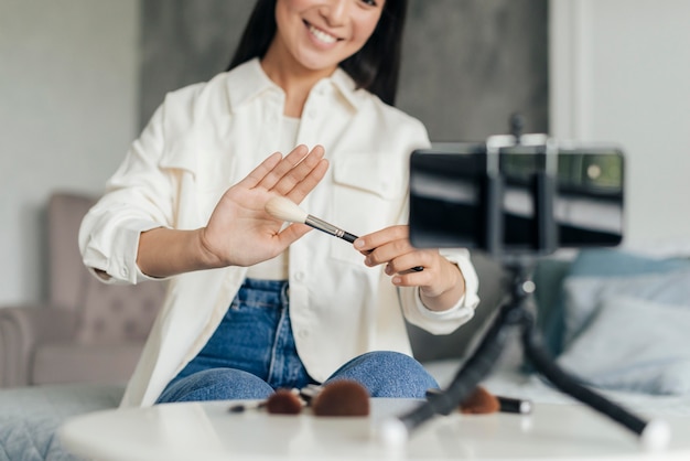 Foto gratuita donna che fa un vlog sul trucco al chiuso