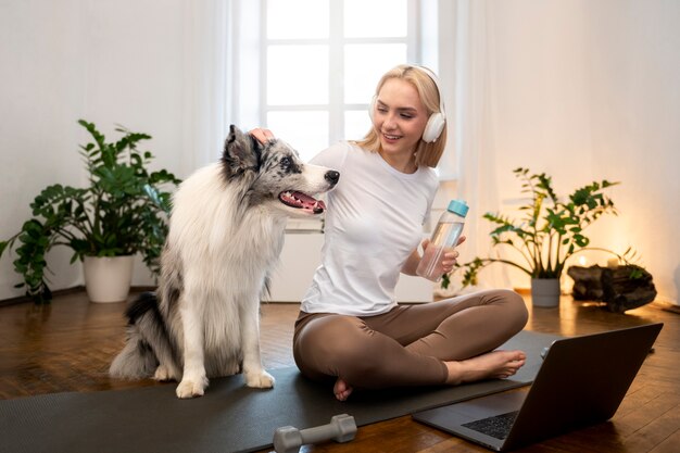 Woman doing yoga accompanied by their pet