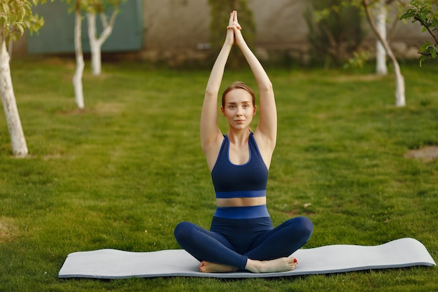 woman doing yoga in a summer park