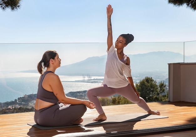 Woman doing yoga with teacher on mat