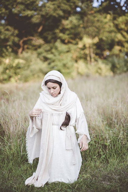 Foto gratuita donna in ginocchio mentre indossa un abito biblico