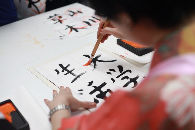 Woman drawing oriental symbols