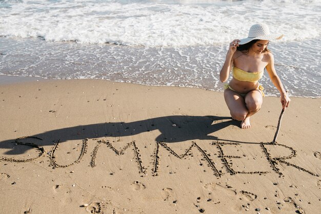 Woman drawing in the sand at the beach