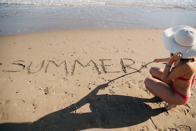 Woman drawing in the sand at the beach