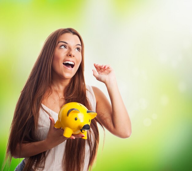 Woman dreaming and holding piglet moneybox