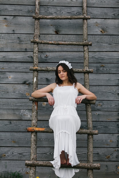 Woman dressed as a bride climbing a wooden stairs