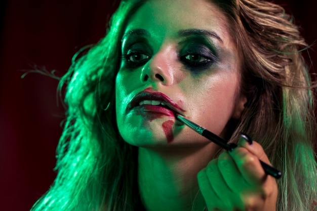 Woman dressed as joker using a brush