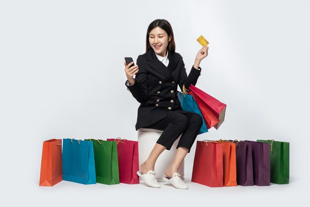 The woman dressed in dark went shopping, carrying credit cards and lots of bags