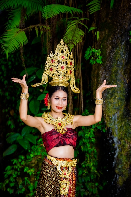 A woman dressed with an ancient Thai dress at the waterfall.