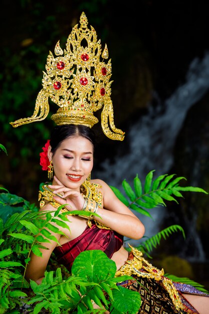 A woman dressed with an ancient Thai dress at the waterfall.