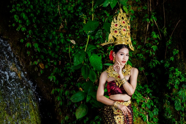 A woman dressed with an ancient Thai dress at the waterfall.