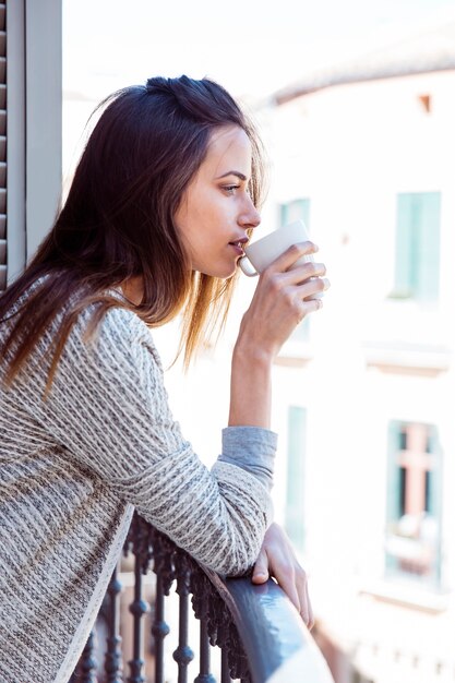 女性、バルコニーで飲む