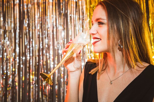 Женщина пьет шампанское на праздновании нового года
