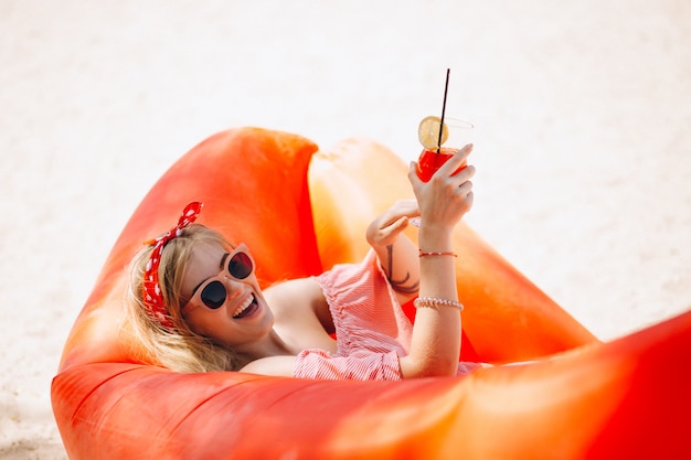 Woman drinking cocktail at the beach