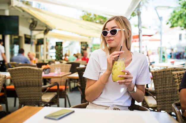 Woman drinking cocktail lemonade in cafe restaurant