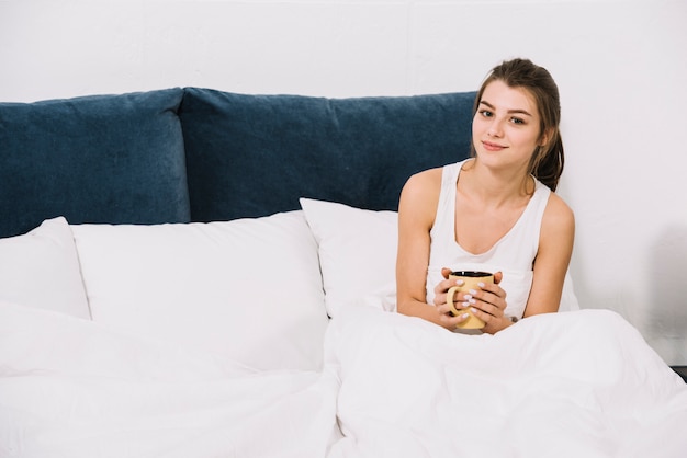 Woman drinking coffee in bed 