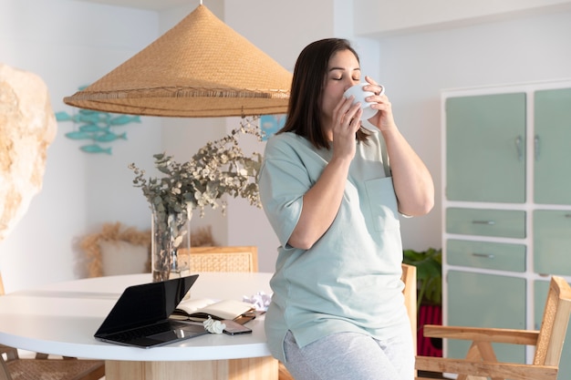 Colpo medio del caffè bevente della donna