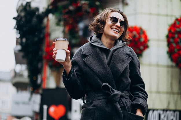 Woman drinking coffee outside the street