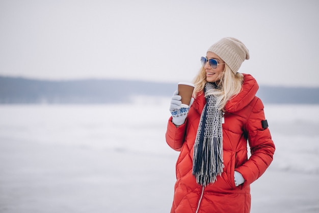 Woman drinking coffee outside in winter