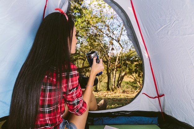 Free photo woman drinking coffee in tent