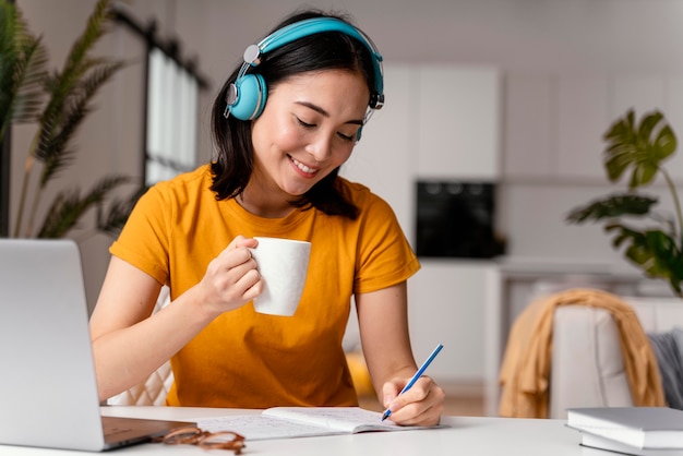 Woman drinking coffee while attending online class