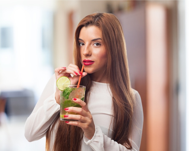 ストローで飲み物を飲む女