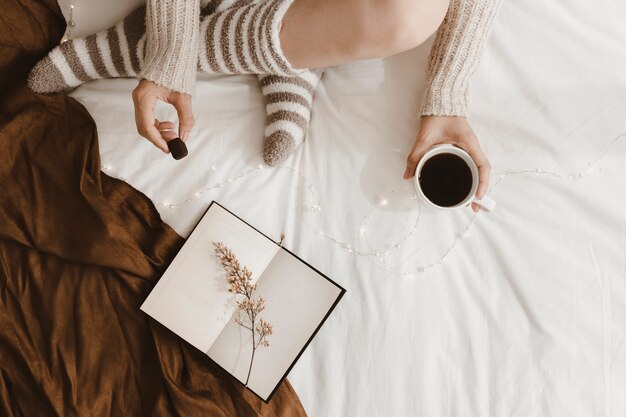 Woman drinking and eating near book