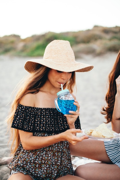Бесплатное фото Женщина, пьющая экзотический напиток на пляже
