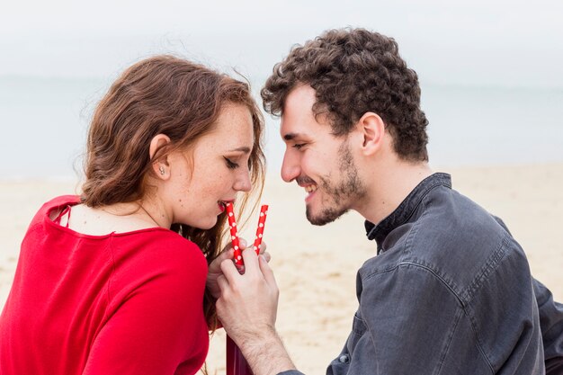 Woman drinking from bottle with straw 