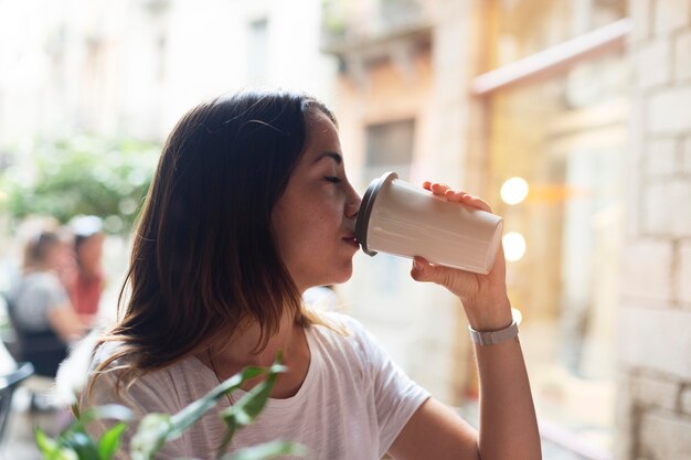 Woman drinking from a sustainable recipient