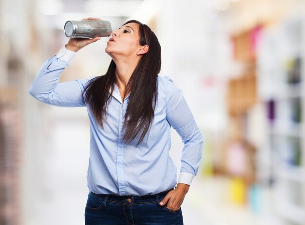 水のボトルから飲む女性