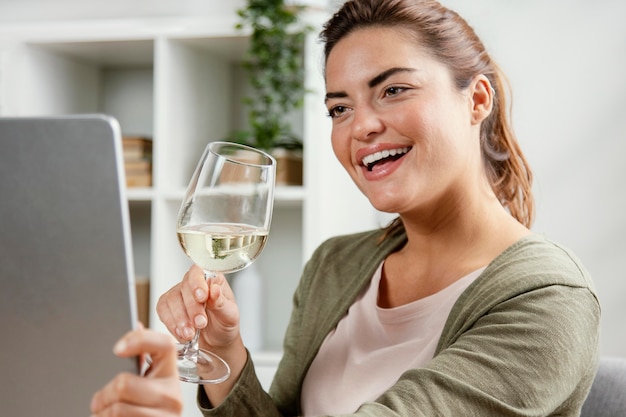 노트북을 사용하는 동안 와인을 마시는 여자