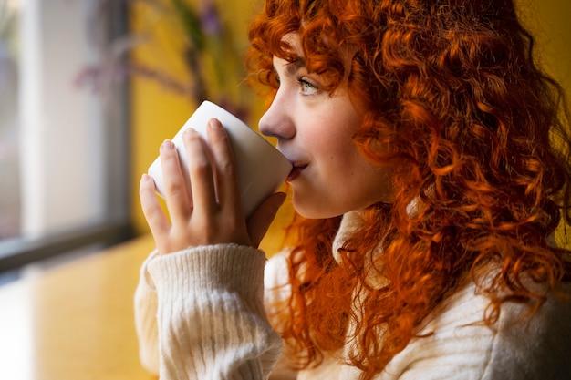 Free photo woman drinking hot chocolate at cafe