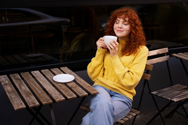 Free photo woman drinking hot chocolate at cafe