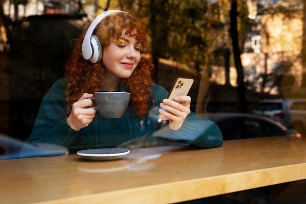 Free photo woman drinking hot chocolate at cafe