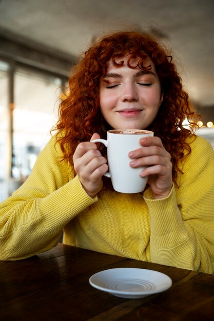 woman drinking hot chocolate at cafe