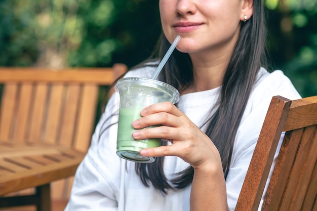 Foto gratuita donna che beve matcha latte, una bevanda fredda sana.