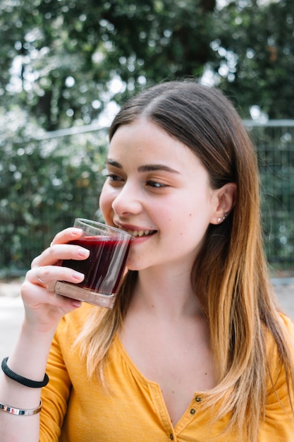 女の子がザクロジュースを飲む