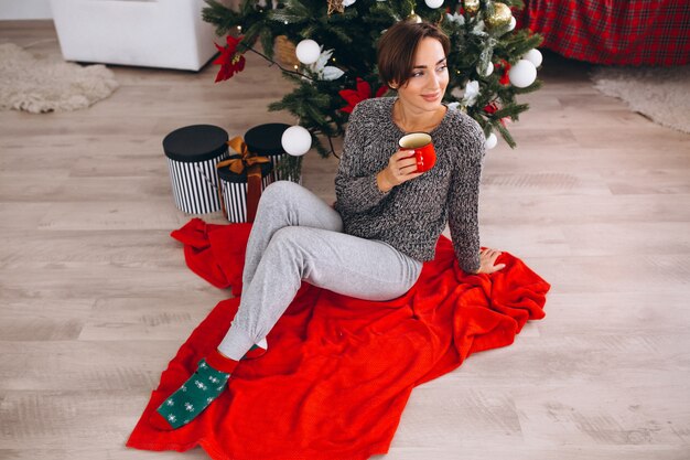 Free photo woman drinking tea on christmas eve