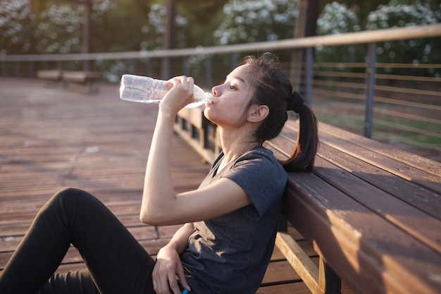 Free photo woman drinking water after training