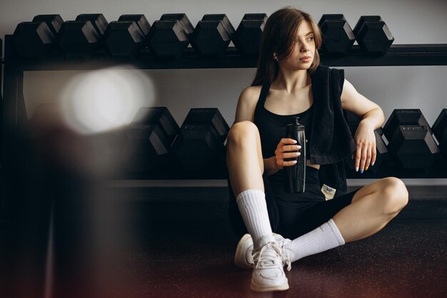 Woman drinking water at the gym