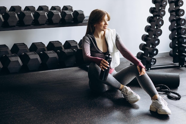 Woman drinking water at the gym