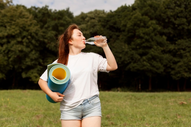 屋外で水を飲む女性